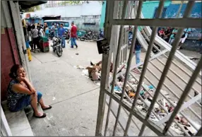  ?? AP/FERNANDO LLANO ?? Shop owner Maria Gonzalez on Friday sits on the front step of her Caracas store, which was looted the night before. At least 12 people were killed in the violence in the Venezuelan capital as the country’s political crisis deepened.