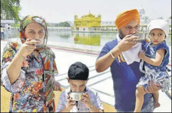  ?? SAMEER SEHGAL/HT ?? Devotees enjoying cold sweetened water at a ‘chabeel’ — put up to mark the martyrdom day of the fifth Sikh master Guru Arjan Dev — at the Golden Temple in Amritsar on Tuesday.