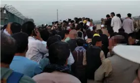  ??  ?? Afghans crowd the road leading to Kabul airport. They are seeking evacuation flights out of the country following the Taliban’s capture of the capital