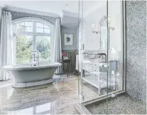  ??  ?? A large freestandi­ng tub and a tiled, glass-enclosed shower stall provide the best of both worlds.