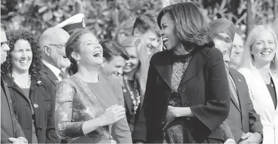  ?? OLIVIER DOULIERY / GETTY IMAGES ?? First Lady Michelle Obama and Sophie Grégoire-Trudeau share a laugh during a ceremony at the White House on Thursday. There was a communal feeling to Justin Trudeau’s first visit to Washington since becoming prime minister, John Ivison writes, and his...