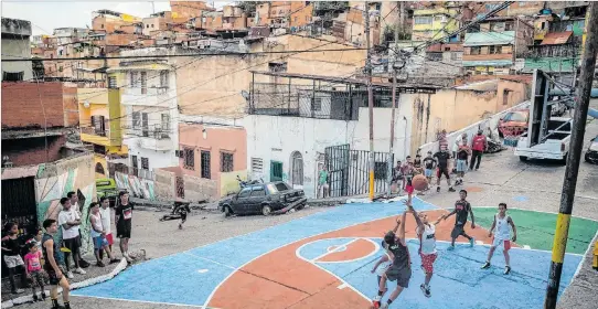  ?? MIGUEL GUTIÉRREZ / EFE ?? Distracció­n. Un grupo de niños y jóvenes juega baloncesto para inaugurar una recién restaurada cancha improvisad­a por los vecinos del barrio. Es su forma de recuperar el espacio.