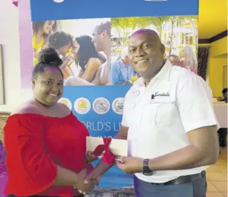  ?? ?? Happy Hearts Early Childhood teacher Nadine Jarrett-salabie is presented with the top prize of a two-night/three-day stay at any Sandals Resort in Jamaica by Beaches Negril General Manager Lancelot Lebert during the resort’s Teachers’ Day celebratio­n.