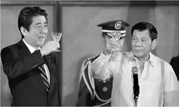  ?? — AFP photo ?? Rodrigo Duterte (right) and Japanese Shinzo Abe raise a toast during a state dinner at the Malacanang Presidenti­al Palace in Manila.