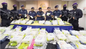  ?? — Photo by Roystein Emmor ?? Norizan (centre) and his officers shows the drugs seized from the house in Matang.