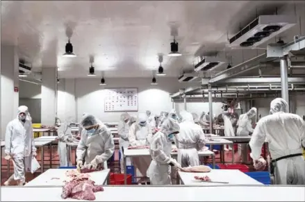  ?? ELI LILLIS ?? Workers process meat at the SLN slaughterh­ouse near Sihanoukvi­lle last year.