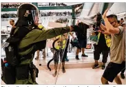  ?? ANTHONY KWAN / GETTY IMAGES ?? Riot police chase protesters through a shopping mall after thousands took part in a march against the territory’s chief executive in Sha Tin district on Sunday in Hong Kong.