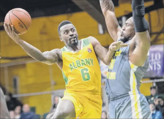  ?? Photos by Jim Franco / Special to the Times Union ?? Albany guard Joshua Cameron makes a move against New York during the Patroons’ home opener on Saturday at Washington Avenue Armory.