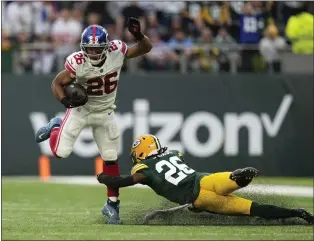  ?? ALASTAIR GRANT — THE ASSOCIATED PRESS ?? Giants running back Saquon Barkley (26) breaks away from Green Bay Packers safety Darnell Savage (26) for a touchdown during the second half at the Tottenham Hotspur Stadium in London on Sunday.