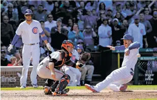  ?? CHARLES REX ARBOGAST/THE ASSOCIATED PRESS ?? The Cubs’ Anthony Rizzo scores Thursday past Giants catcher Buster Posey after Kris Bryant, left, scored on a wild pitch during the eighth inning of a game in Chicago. The Cubs won, 5-1.