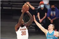  ?? Elsa / Associated Press ?? The Knicks’ Julius Randle takes a 3-point shot over the Hornets’ Cody Zeller on Saturday.