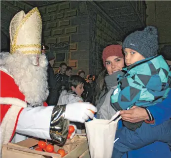  ?? FOTO: KST ?? Der Stadtnikol­aus füllt den Beutel vom dreijährig­en Keno mit Mandarinen.