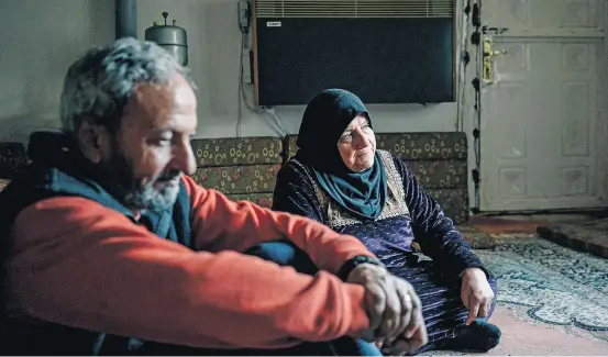  ?? ALICE MARTINS/WASHINGTON POST ?? Trabalho forçado. Samira ao lado de seu marido, Hassan al-Hammam, na sala de sua casa em Raqqa, na Síria: encarregad­a das ‘crianças do califado’