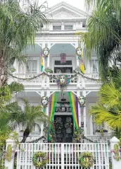  ??  ?? The owners of a Market Street home get in the Mardi Gras spirit by decorating the porch and balcony.