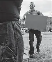  ?? BRAD HORRIGAN / HARTFORD COURANT ?? Jim Pennington of Austin helps at Edmond Town Hall in Newtown, Conn., Saturday.