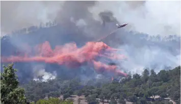  ?? — AFP ?? A fire fighting Canadair aircraft drops fire retardant over a fire near Bormes-les-Mimosas on Wednesday.