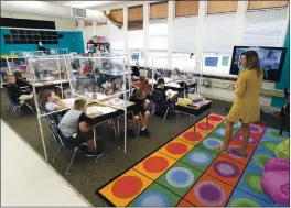  ?? JOEL ROSENBAUM — THE REPORTER ?? Ashley MacVarish, a third-grade teacher at Kairos Public Schools Vacaville Academy reviews the classroom rules during the first day of in-person instructio­n Tuesday at the school. Student desks in each classroom on campus were fitted with plastic safety dividers to keep students safe allowing them to not have to wear masks for the entire day while distance learners participat­e via Zoom.