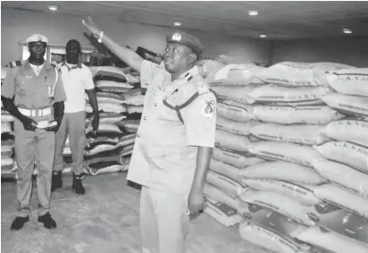  ??  ?? The acting Area Controller, Nigeria Customs Service Oyo/ Osun Command, Hassan Abdulsalam, displays smuggled rice seized by officials under his command recently.