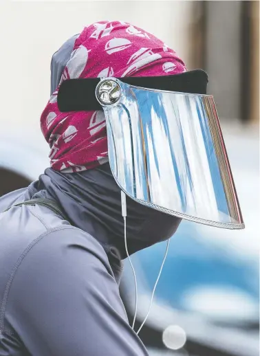  ?? PETER J THOMPSON/NATIONAL POST ?? A cyclist in Toronto Thursday wears a mask, head scarf and face shield. A review published in the medical journal Lancet suggests shields, visors or goggles might significan­tly reduce the chance of viral infection or transmissi­on.