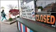  ?? (AP Photo/Tony Dejak, File) ?? A woman walks past a closed barber shop May 6 in Cleveland. Small businesses are in limbo again as the coronaviru­s outbreak rages and the government’s $659 billion relief program draws to a close. Companies still struggling with sharply reduced revenue are wondering if Congress will give them a second chance at the Paycheck Protection Program, which ended Friday, after giving out 5.1 million loans worth $523 billion.