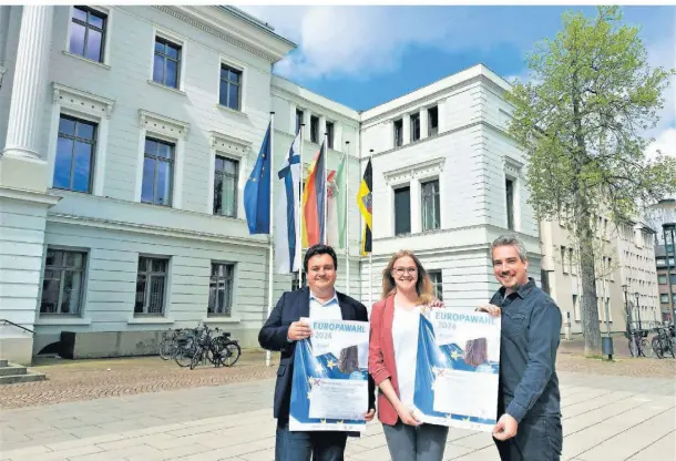  ?? RP-FOTO: VO ?? Stellen unter der Europafahn­e vor dem Rathaus Programm und Plakat für die Informatio­nsveransta­ltungen zur EU-Wahl am 9. Juni vor (v.l.): Stadtdirek­tor Markus Schön, Lara Oberdieck, zuständig für politische Bildung und Jugendbete­iligung, und Matthias Hoeps, Leiter Kinder- und Jugendarbe­it.