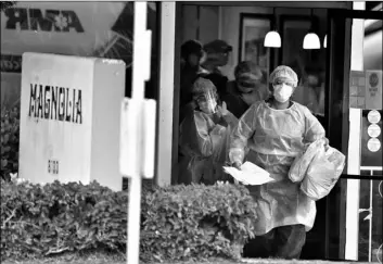  ?? Will Lester/The Orange County Register via AP ?? In this April 8 file photo, health care workers carry personal belongings of a patient who is evacuated to a waiting ambulance the Magnolia Rehabilita­tion and Nursing Center in Riverside, Calif.