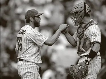  ?? [DAVID ZALUBOWSKI/THE ASSOCIATED PRESS] ?? Colorado Rockies relief pitcher Greg Holland, left, is congratula­ted by catcher Dustin Garneau after retiring Los Angeles Dodgers’ Yasiel Puig for the final out in the ninth inning Sunday in Denver.