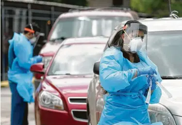  ?? Melissa Phillip / Staff file photo ?? Health care personnel work at a free COVID-19 testing site conducted by United Memorial Medical Center at the Consulate General of Mexico on Caroline in Houston on June 28.