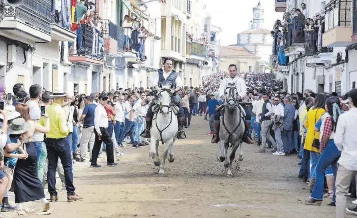  ?? LORENZO CORDERO ?? Dos jinetes bajando juntos la simbólica Corredera, ayer en las fiestas de Arroyo de la Luz.