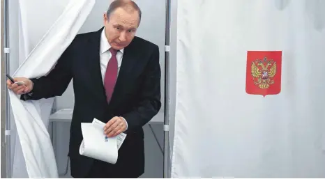  ?? FOTO: AFP ?? Vorhang auf für den alten und neuen Kremlchef: Wladimir Putin bei der Stimmabgab­e am Sonntag.