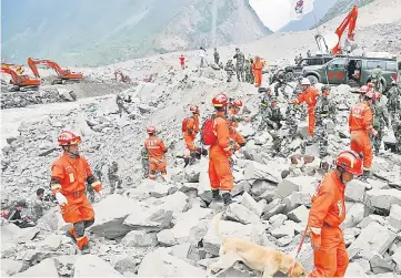  ??  ?? Rescue workers search for survivors at the site of a landslide in the village of Xinmo. — Reuters photo