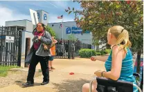  ?? JIM SALTER/ASSOCIATED PRESS ?? Teresa Pettis, 21, right, greets a passerby Friday outside Planned Parenthood in St. Louis. Pettis was one of a small number of abortion opponents protesting outside the clinic on the day the Missouri Legislatur­e passed a sweeping measure banning abortions at eight weeks of pregnancy.