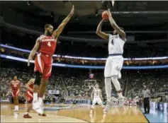  ?? KEITH SRAKOCIC — THE ASSOCIATED PRESS ?? Villanova’s Eric Paschall, right hits a 3-point shot over Alabama’s Daniel Giddens, left, during the second half of a second-round game in the NCAA men’s tournament on Saturday, in Pittsburgh. Villanova won, 81-58.