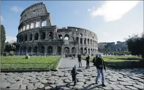  ?? GREGORIO BORGIA/ THE ASSOCIATED PRESS ?? Tourists walk outside Rome’s Colosseum on Friday. A restoratio­n of a passageway shows the arena where gladiators fought had “extreme contrasts of colour” in its heyday.