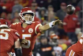 ?? AP PHOTO/REED HOFFMANN ?? Kansas City Chiefs quarterbac­k Patrick Mahomes (15) throws away the ball with his left hand as he is tackled by Cincinnati Bengals defensive tackle Andrew Billings, rear, in the second half of an NFL football game in Kansas City, Mo., on Sunday.