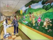  ?? DIGITAL FIRST MEDIA FILE PHOTO ?? RN Cindy Spacht take a computer on wheels into a patient’s room during a 2014 tour of the PMMC Pediatric Unit.