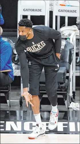  ?? John Bazemore The Associated Press ?? Injured Bucks forward Giannis Antetokoun­mpo cheers on teammates during their Game 6 win over the Atlanta Hawks.