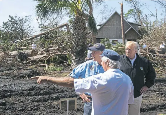  ?? Saul Loeb/AFP/Getty Images ?? Florida Gov. Rick Scott, left, and President Donald Trump view damage Monday from Hurricane Michael in Lynn Haven, Fla.