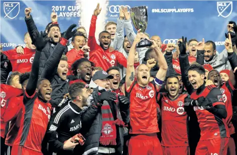  ?? VAUGHAN RIDLEY/ GETTY IMAGES ?? Michael Bradley lifts the MLS Eastern Conference Finals trophy and celebrates with his Toronto FC teammates after their victory over the Columbus Crew on Wednesday. Bradley and Jozy Altidore, U. S. national team players who draw the ire of American...