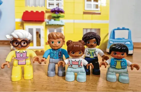  ?? Foto: Insa Sanders, dpa ?? Duplo-Figuren stehen vor einem Haus: Oma, Eltern und Kinder. Sie symbolisie­ren eine Familie, die aus drei Generation­en besteht.