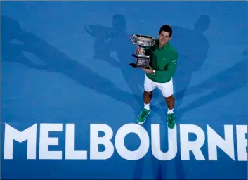  ?? AP Photo/Andy Wong ?? In this Feb. 3 file photo, Serbia’s Novak Djokovic holds the Norman Brookes Challenge Cup after defeating Austria’s Dominic Thiem in the men’s singles final of the Australian Open tennis championsh­ip in Melbourne, Australia.