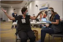  ??  ?? Nurse Heather Donaldson administer­s the first COVID- 19 vaccinatio­n at UC Davis Health to emergency medicine nurse Eva Teniola.