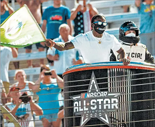  ?? DAVID CRIGGER/AP ?? Former University of Tennessee and current Saints running back Alvin Kamara waves the green flag to start the NASCAR All-Star auto race Wednesday in Bristol, Tenn.