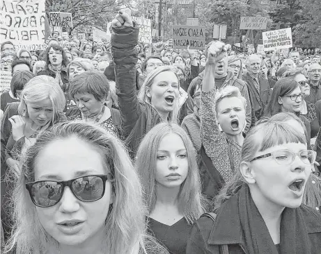  ?? Czarek Sokolowski / Associated Press ?? Protesters at the Polish Parliament in Warsaw on Saturday wore black to symbolize mourning for their loss of reproducti­ve rights.