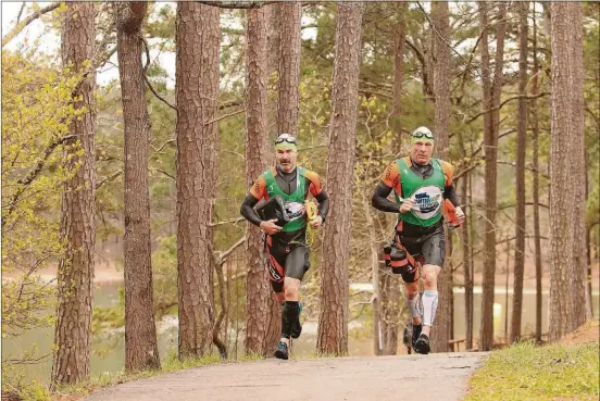  ?? PHOTOS CONTRIBUTE­D BY TIM NETTLETON ?? Marcus Barton and Dan Kimball of Team Orca on their way to winning the long course version of SwimRun Georgia on April 8.