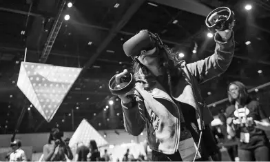  ?? DAVID PAUL MORRIS / BLOOMBERG VIA GETTY IMAGES ?? A visitor operates a VR headset of Oculus during a high-tech exhibition in the United States. The company and its Chinese partner are tapping the domestic market with affordable and high-quality VR products.