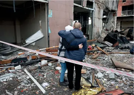  ?? GETTY IMAGES ?? A couple look at the destructio­n left by a Russian missile in Lviv yesterday, before the start of Russia’s offensive in eastern Ukraine. Seven people were killed in the first attack on Lviv since the war began in February.