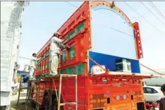  ?? AFP ?? Artist Haider Ali (left) works on a truck at a workshop in Karachi on February 28.