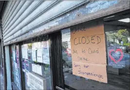 ?? The Associated Press ?? John Minchillo
A store in the Far Rockaway neighborho­od of Queens, N.Y., remains shuttered Thursday because of an increase in the COVID-19 infection rate.