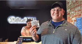  ?? DAVID BECKER/GETTY IMAGES FOR WILLIAM HILL US ?? James Adducci shows his winning Masters bet tickets at the William Hill Sports Book at SLS Las Vegas Hotel on Monday.